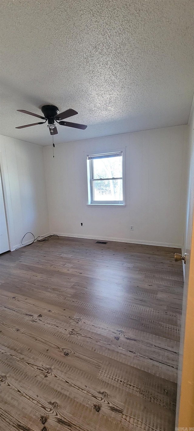 spare room featuring hardwood / wood-style floors and a textured ceiling