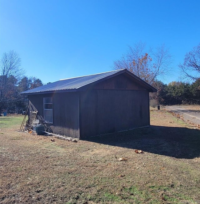 view of property exterior featuring an outdoor structure and a lawn