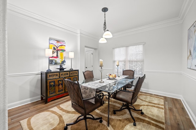 dining area with wood-type flooring and ornamental molding