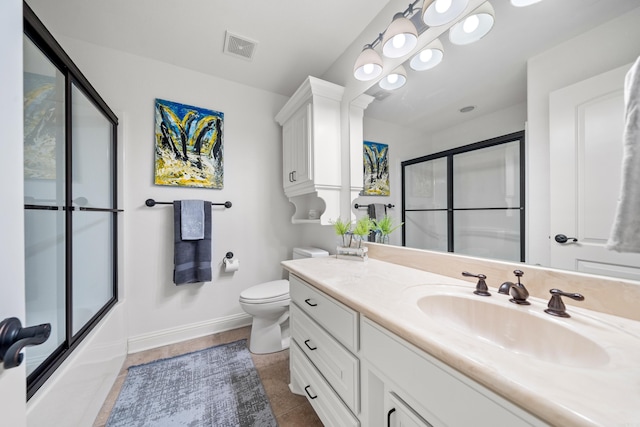 full bathroom with tile patterned floors, vanity, toilet, and bath / shower combo with glass door