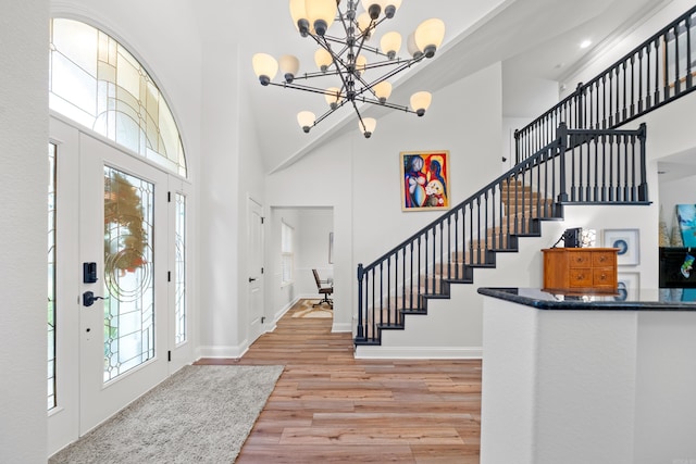 entryway featuring a chandelier, a high ceiling, and light wood-type flooring