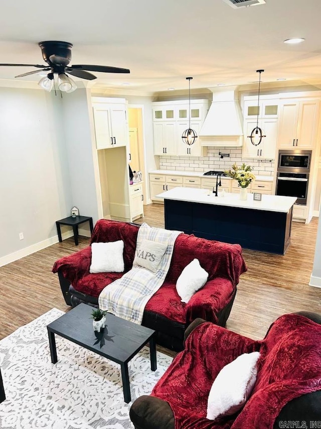 living room with ceiling fan and light wood-type flooring