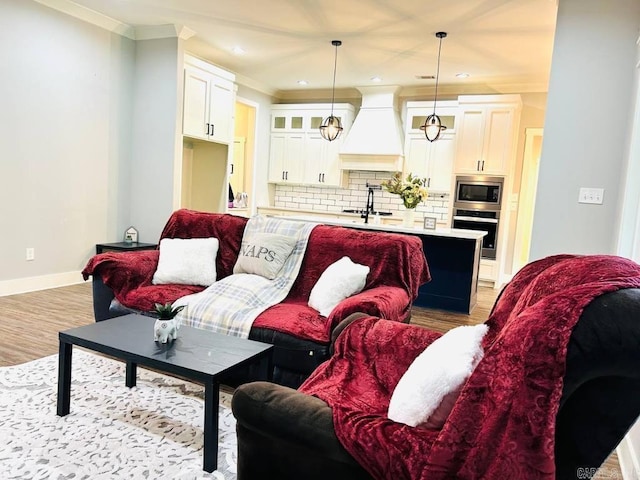 living room with light wood-type flooring and ornamental molding