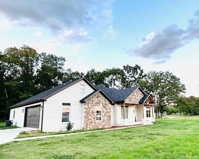 view of front of home with a front yard, a garage, and cooling unit