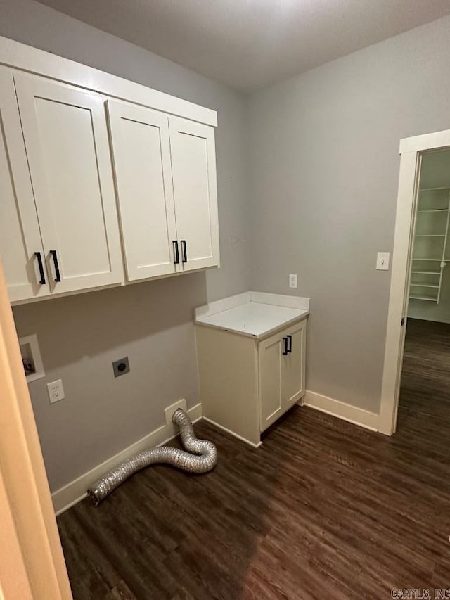 laundry area featuring electric dryer hookup, dark hardwood / wood-style flooring, and cabinets