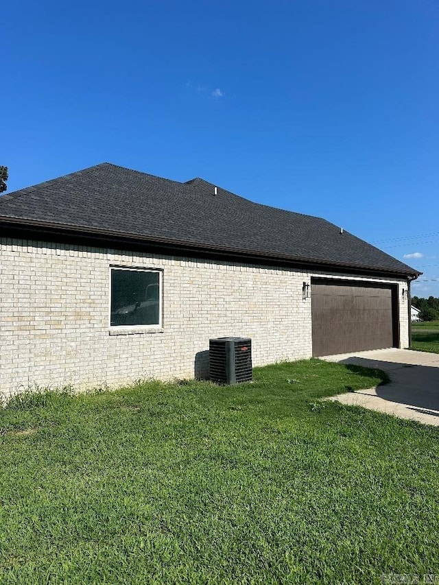 view of home's exterior featuring a lawn, central AC unit, and a garage