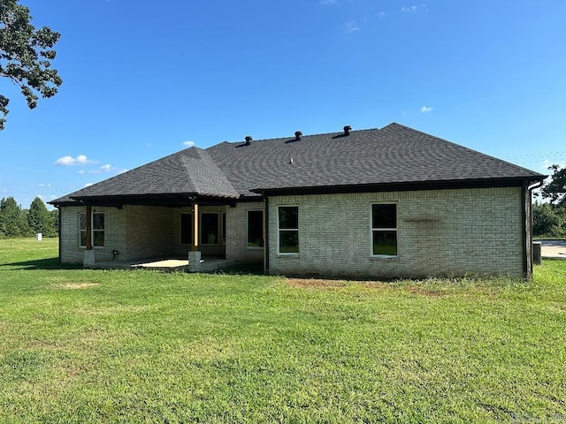 rear view of house featuring a patio and a lawn