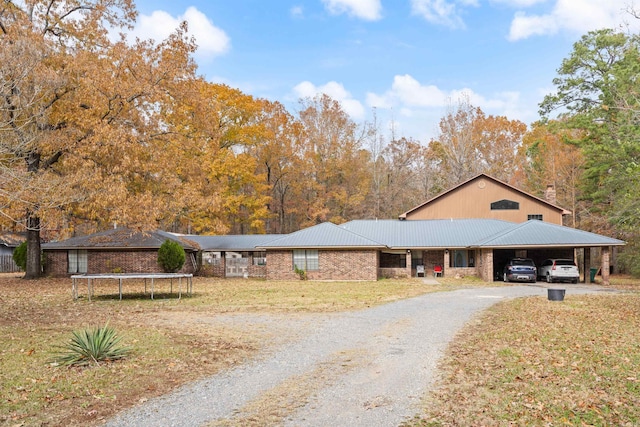 ranch-style home featuring a carport, a trampoline, and a front yard