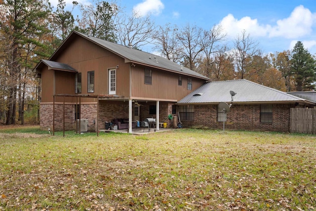 rear view of house with a lawn, cooling unit, and a patio area