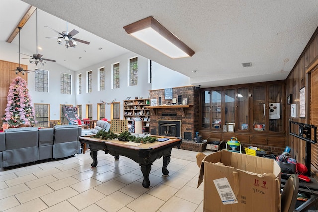 rec room featuring beam ceiling, ceiling fan, billiards, wood walls, and a fireplace