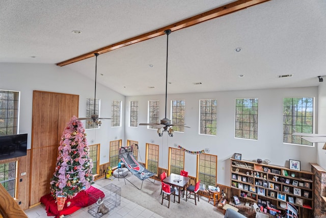 game room with vaulted ceiling with beams, ceiling fan, light colored carpet, and a textured ceiling