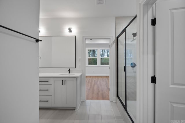 bathroom with vanity, an enclosed shower, and wood-type flooring