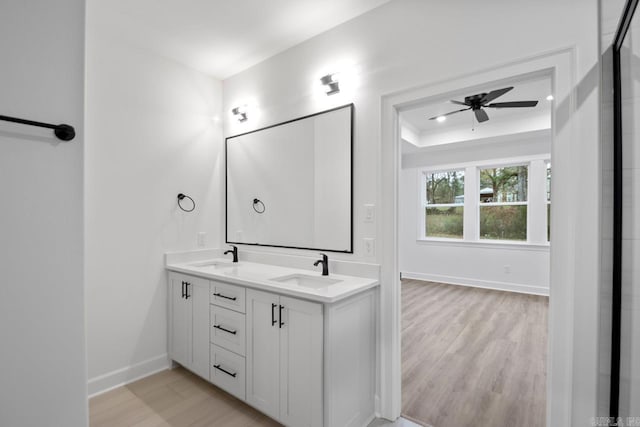 bathroom with hardwood / wood-style floors, ceiling fan, and vanity