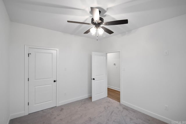 unfurnished bedroom with ceiling fan and light colored carpet