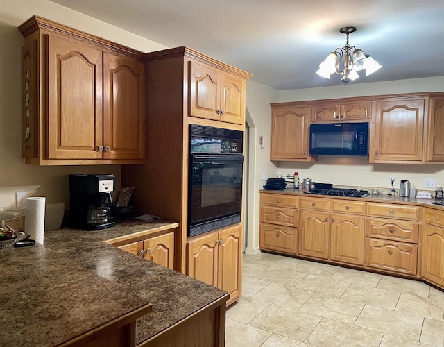 kitchen with black appliances, hanging light fixtures, and a chandelier