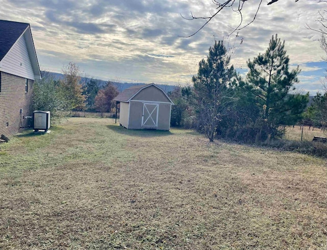 view of yard with central AC and a storage unit