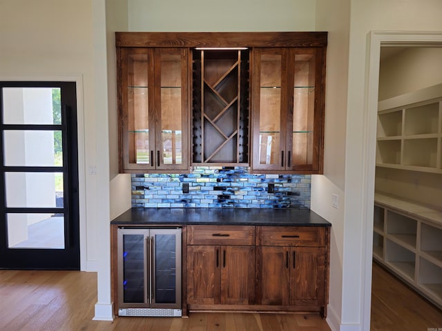 bar featuring tasteful backsplash, wine cooler, and light hardwood / wood-style floors