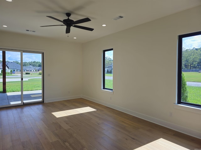 spare room with ceiling fan, dark hardwood / wood-style flooring, and a wealth of natural light