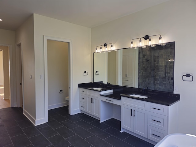 bathroom with toilet, vanity, and tile patterned floors