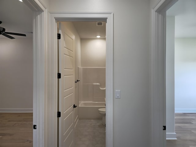 bathroom featuring shower / bathtub combination, hardwood / wood-style flooring, toilet, and ceiling fan