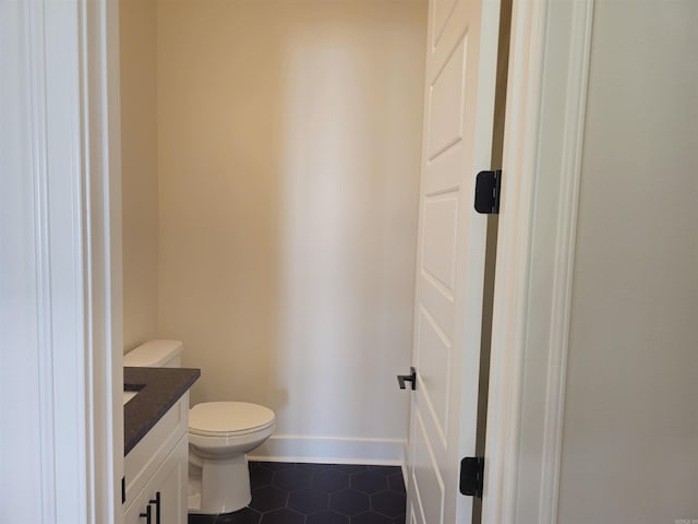 bathroom featuring toilet, vanity, and tile patterned floors