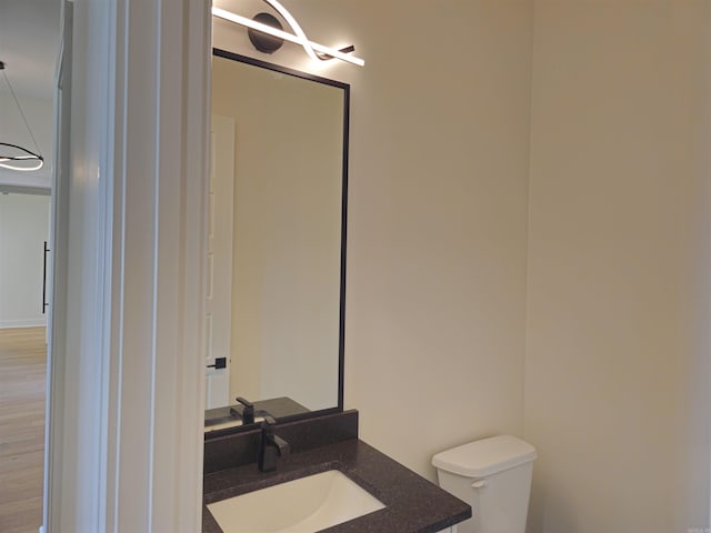 bathroom featuring hardwood / wood-style floors, vanity, and toilet