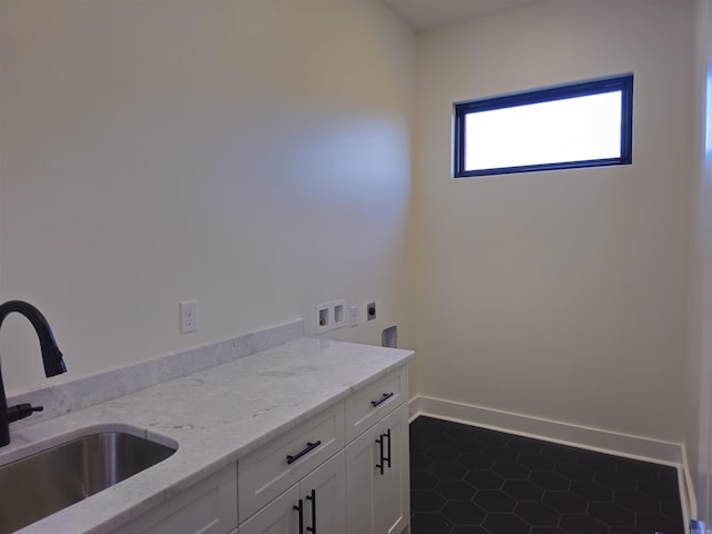 washroom with cabinets, hookup for a washing machine, electric dryer hookup, sink, and dark tile patterned flooring