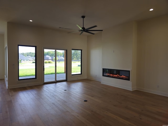 unfurnished living room featuring ceiling fan, a healthy amount of sunlight, and hardwood / wood-style flooring