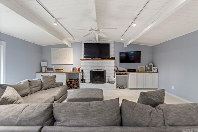 living room with light carpet, rail lighting, a brick fireplace, vaulted ceiling with beams, and ceiling fan