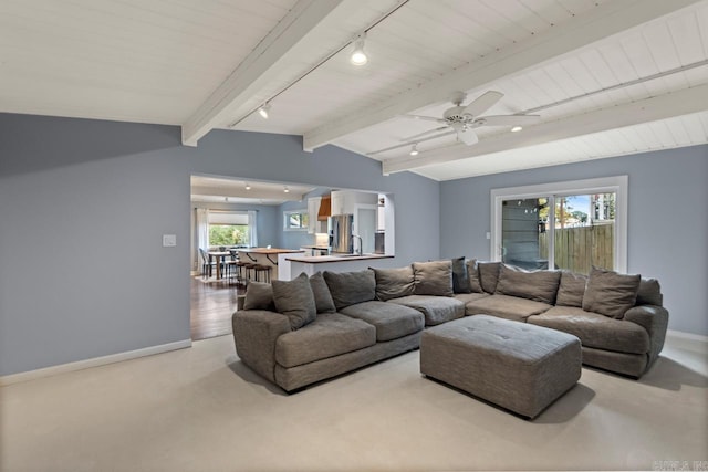 living room with plenty of natural light, lofted ceiling with beams, light hardwood / wood-style floors, and ceiling fan