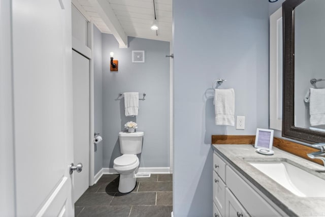 bathroom with tile patterned flooring, vanity, vaulted ceiling, and toilet