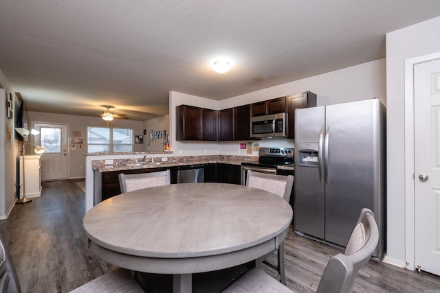 kitchen with hardwood / wood-style floors, dark brown cabinets, stainless steel appliances, and sink