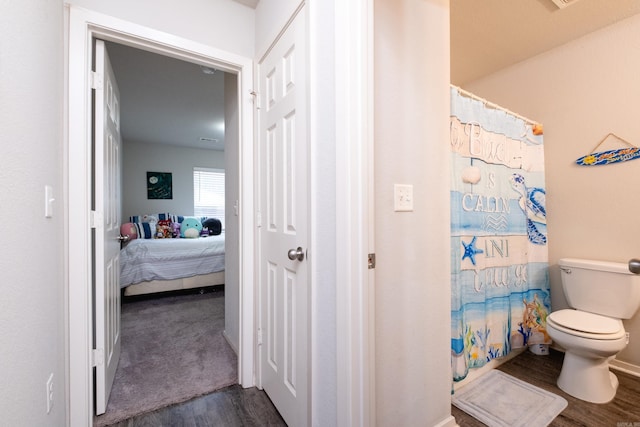 bathroom with hardwood / wood-style flooring and toilet