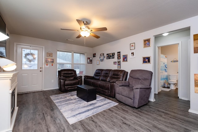 living room featuring ceiling fan and dark wood-type flooring