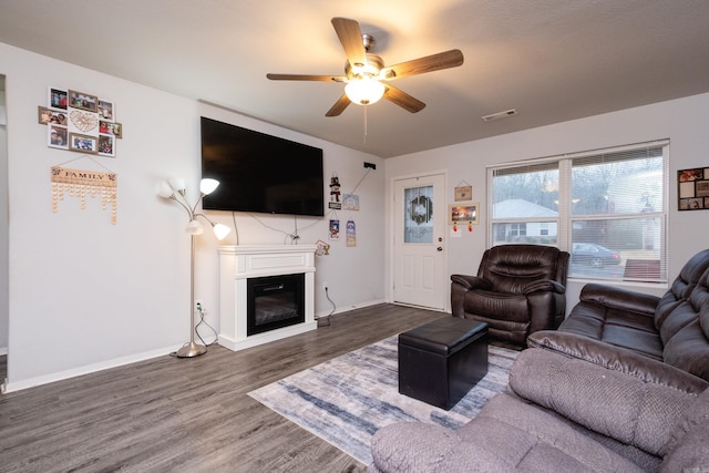 living room featuring ceiling fan and dark hardwood / wood-style flooring