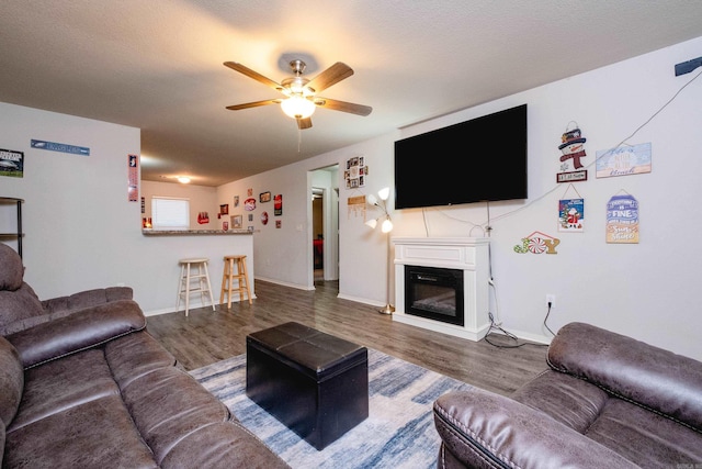 living room featuring hardwood / wood-style floors, a textured ceiling, and ceiling fan