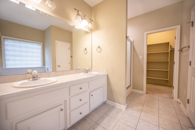 bathroom with tile patterned flooring, vanity, and a shower with door