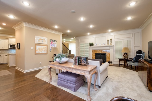 living room featuring crown molding, a fireplace, and wood-type flooring