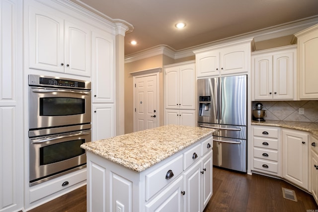 kitchen with white cabinetry, crown molding, dark wood-type flooring, and appliances with stainless steel finishes