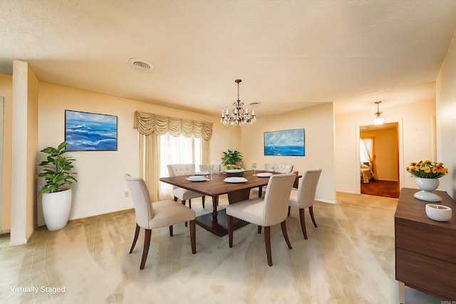 dining area featuring light colored carpet, a textured ceiling, and a chandelier