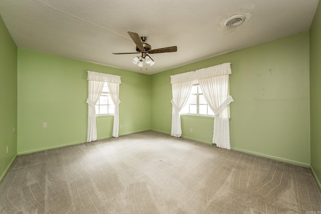 empty room featuring carpet, plenty of natural light, and ceiling fan