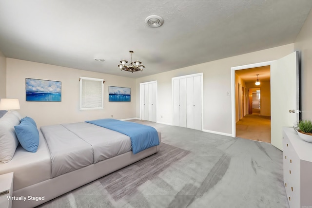 bedroom featuring light colored carpet and an inviting chandelier