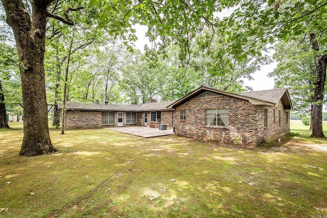 rear view of house featuring a patio and a lawn