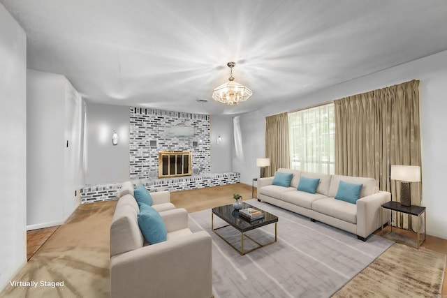 living room with a fireplace, a chandelier, and light wood-type flooring