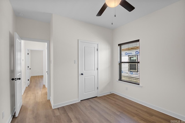 unfurnished bedroom featuring ceiling fan, light hardwood / wood-style floors, and a closet