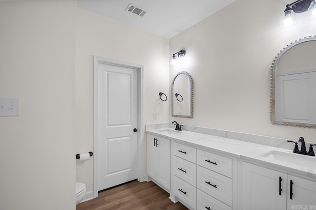 bathroom with hardwood / wood-style floors, vanity, and toilet