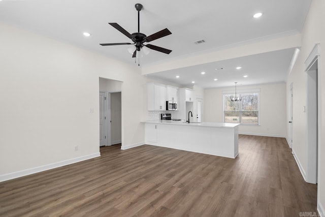 kitchen featuring white cabinetry, sink, stainless steel appliances, dark hardwood / wood-style floors, and kitchen peninsula