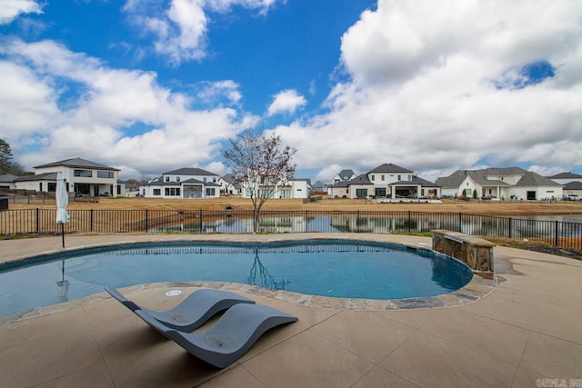 view of swimming pool with a patio area and a water view