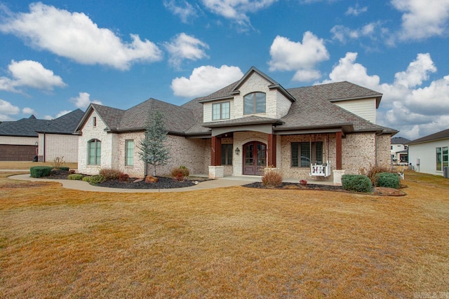 french country inspired facade featuring a front yard, french doors, and a porch