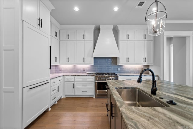 kitchen featuring white cabinets, custom exhaust hood, high quality appliances, and light stone countertops